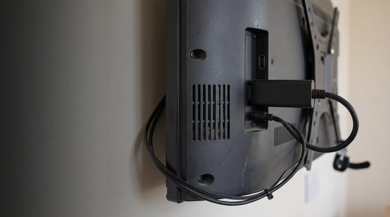 A Fire TV Stick plugged into the HDMI port of a wall mounted display